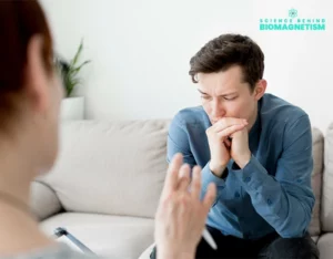 A therapist sitting across from a patient, both engaged in conversation during a Biomagnetism therapy session